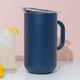 Blue pitcher with a glass of lemonade and lemons on a light pink background